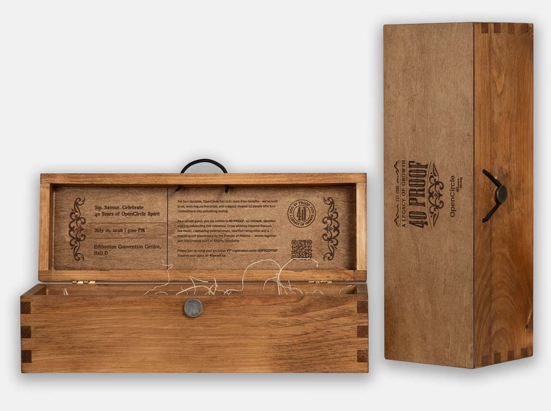 Stained pine single-bottle box with box joint corners, laser engraved with the OpenCircle "40 Proof" anniversary artwork, shown open with an engraved event invitation inside the lid and wood excelsior.