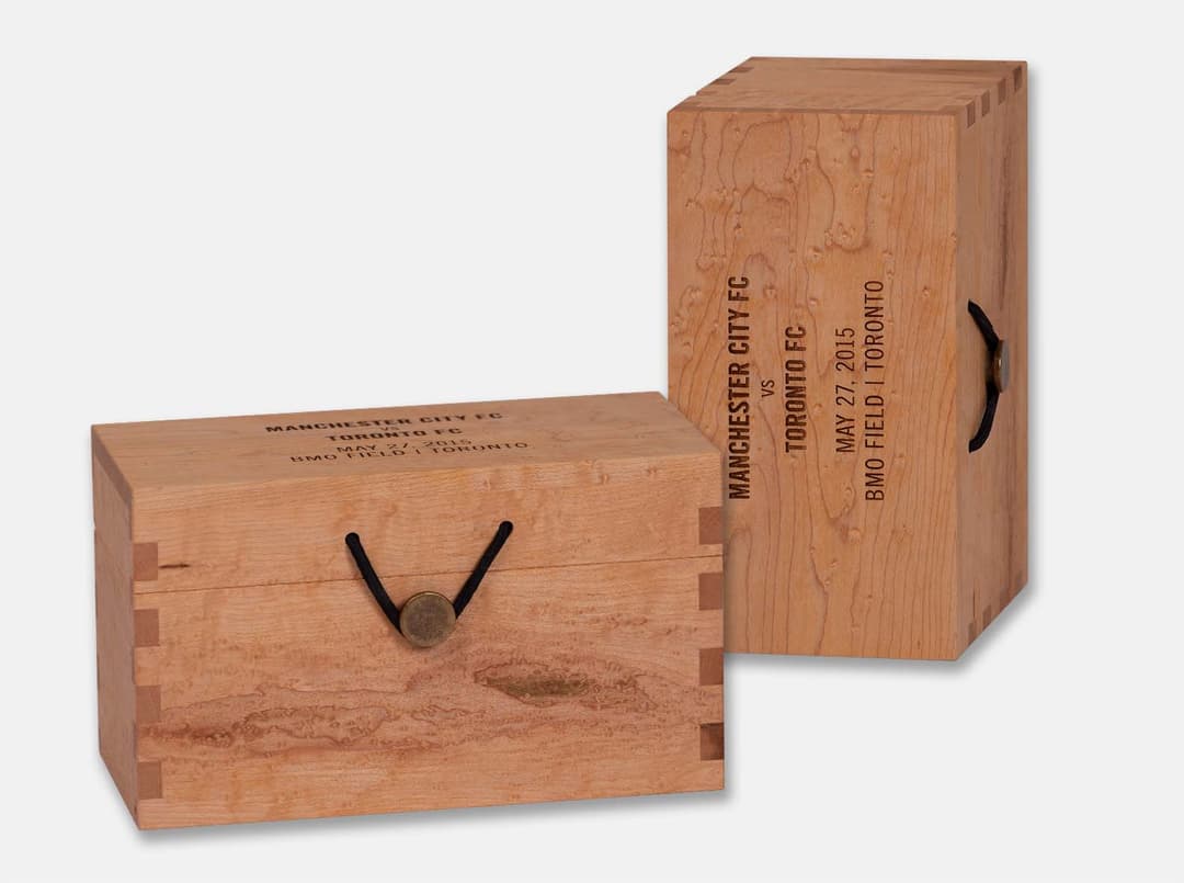 Two dovetailed maple syrup boxes laser engraved for the Manchester City FC vs. Toronto FC match
